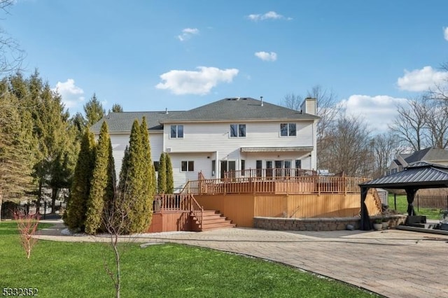 back of house featuring a gazebo, a yard, and a deck