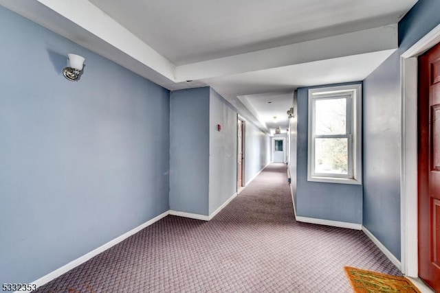 hallway with light carpet and baseboards