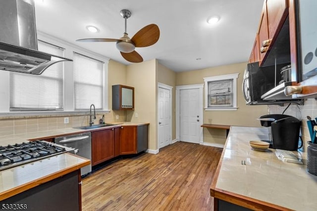 kitchen featuring extractor fan, sink, backsplash, stainless steel dishwasher, and light hardwood / wood-style flooring