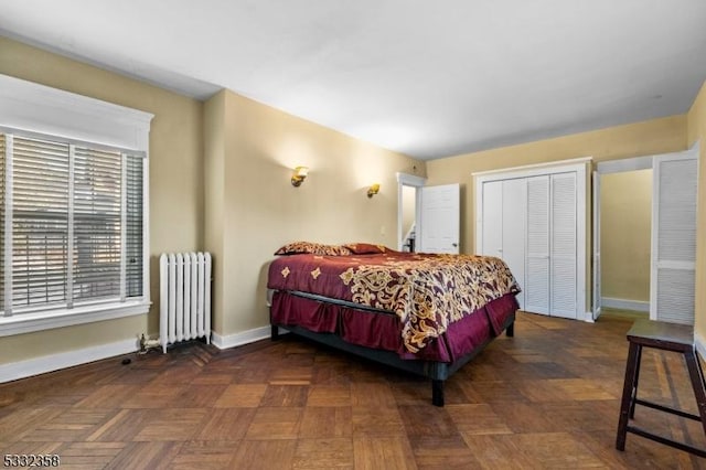 bedroom with dark parquet flooring, radiator, and a closet