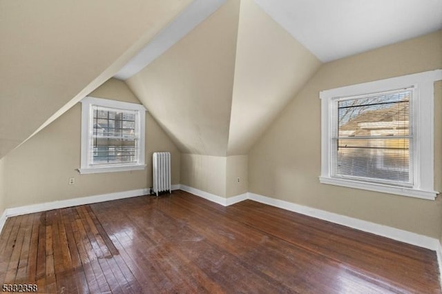 bonus room featuring dark wood-type flooring, radiator heating unit, and vaulted ceiling