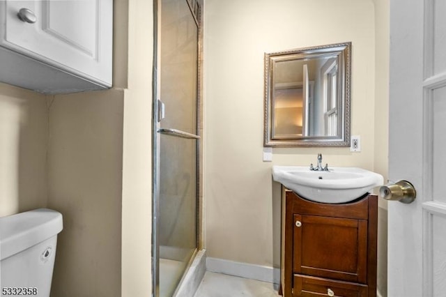 bathroom featuring an enclosed shower, vanity, and toilet