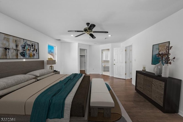 bedroom featuring ensuite bath, a spacious closet, a closet, dark hardwood / wood-style flooring, and ceiling fan