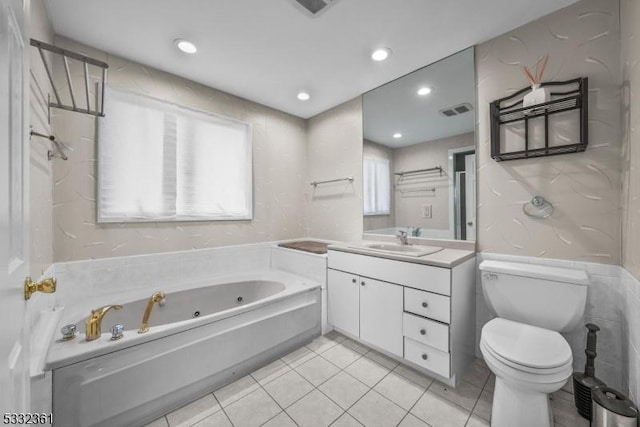 bathroom with toilet, vanity, a tub to relax in, and plenty of natural light