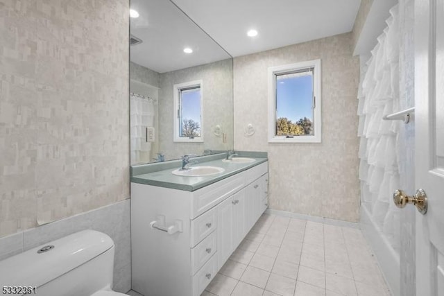 full bathroom featuring tile patterned flooring, shower / bath combo with shower curtain, vanity, and toilet