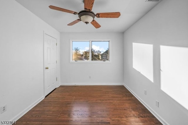 empty room with ceiling fan and dark wood-type flooring