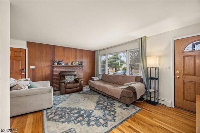 living room with a baseboard heating unit and hardwood / wood-style floors