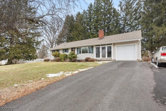 ranch-style home featuring a front lawn and a garage