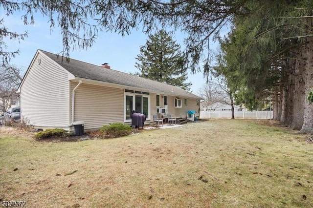 rear view of property featuring a patio and a lawn