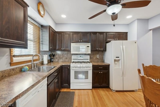 kitchen with sink, white appliances, light wood-type flooring, ceiling fan, and decorative backsplash