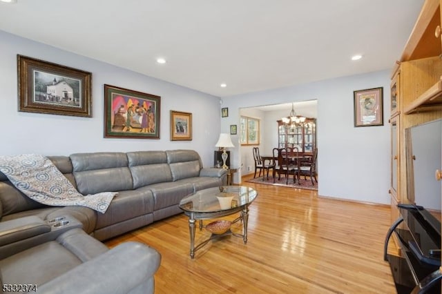 living room with light hardwood / wood-style flooring and an inviting chandelier