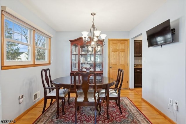 dining area featuring an inviting chandelier and light hardwood / wood-style flooring