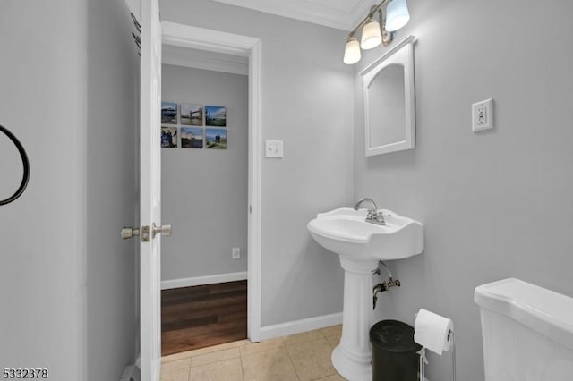 bathroom featuring toilet, tile patterned flooring, and ornamental molding