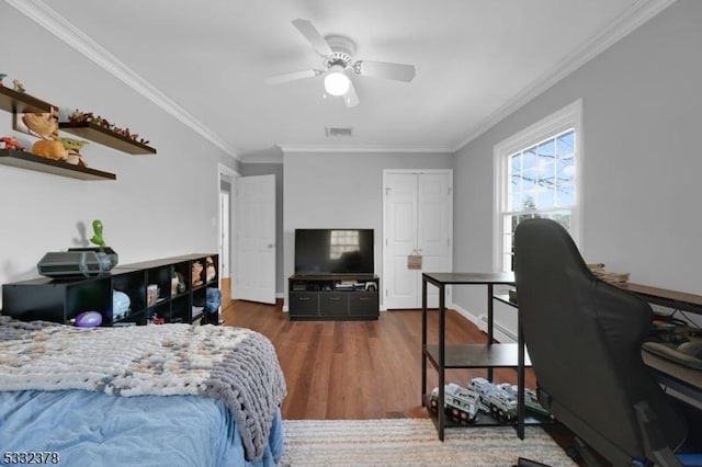 bedroom featuring dark hardwood / wood-style flooring, ceiling fan, and ornamental molding