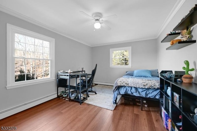 bedroom featuring a baseboard heating unit, ceiling fan, crown molding, and hardwood / wood-style floors