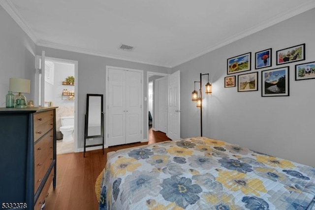 bedroom with ensuite bath, ornamental molding, and dark wood-type flooring