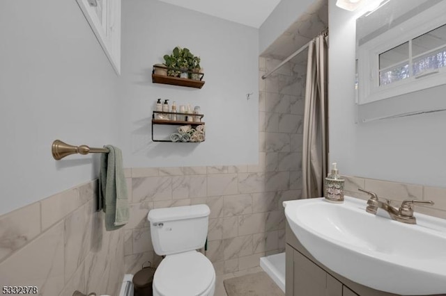 bathroom featuring tile walls, toilet, walk in shower, vanity, and baseboard heating