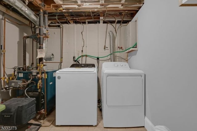 laundry area with washer and dryer and light tile patterned floors