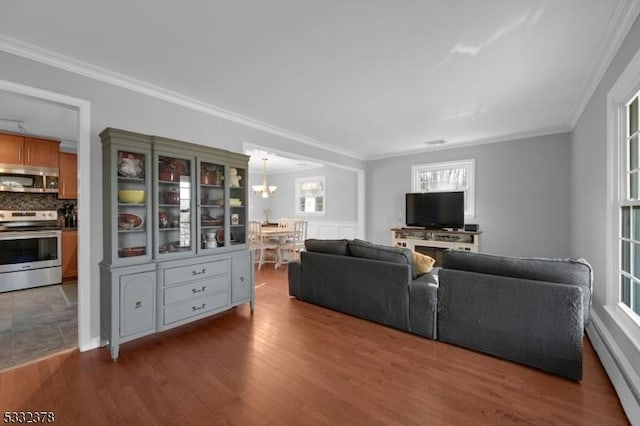 living room with a baseboard heating unit, a notable chandelier, crown molding, and dark hardwood / wood-style flooring