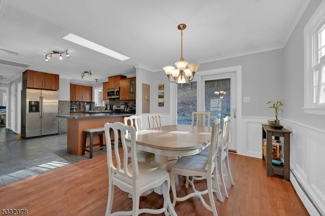 dining area with a notable chandelier, plenty of natural light, and crown molding