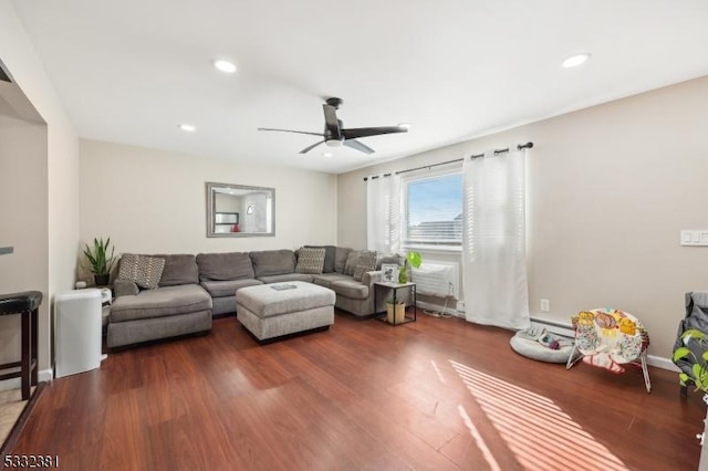 living room featuring a baseboard heating unit, ceiling fan, and dark hardwood / wood-style floors