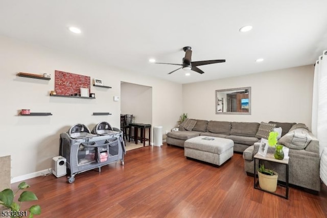 living room featuring ceiling fan and dark wood-type flooring