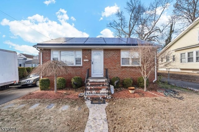 bungalow-style home featuring solar panels