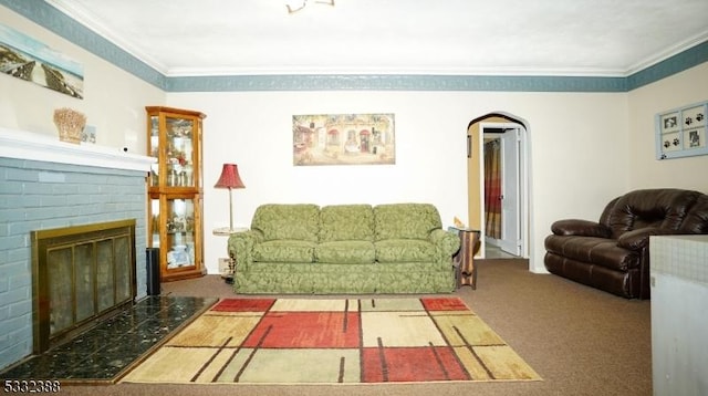 living room featuring dark colored carpet, ornamental molding, and a brick fireplace