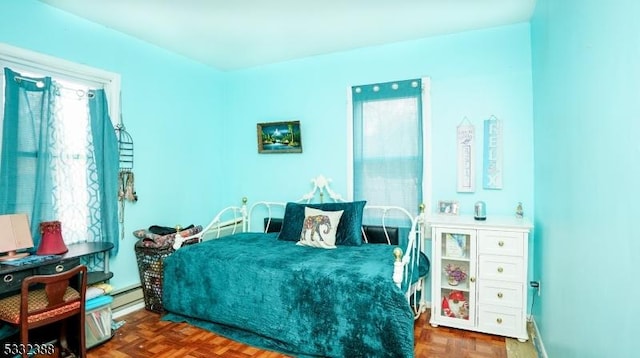 bedroom featuring dark parquet flooring, baseboard heating, and multiple windows