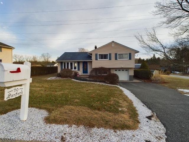 tri-level home with a garage and a front lawn