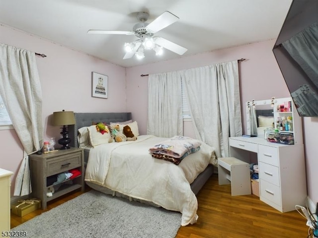 bedroom with ceiling fan and dark hardwood / wood-style flooring