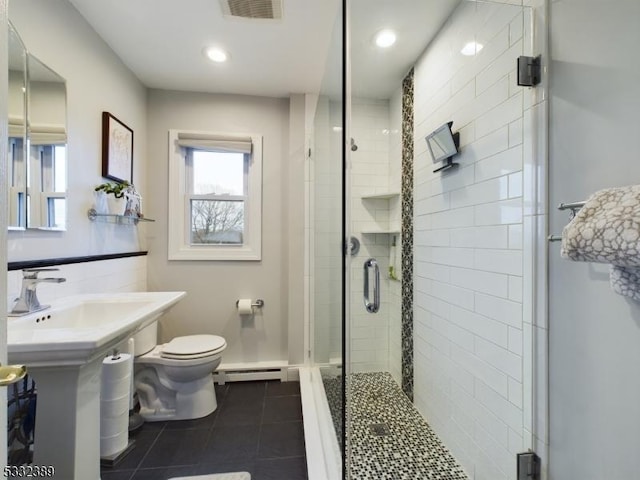 bathroom featuring sink, a baseboard heating unit, tile patterned floors, toilet, and a shower with door