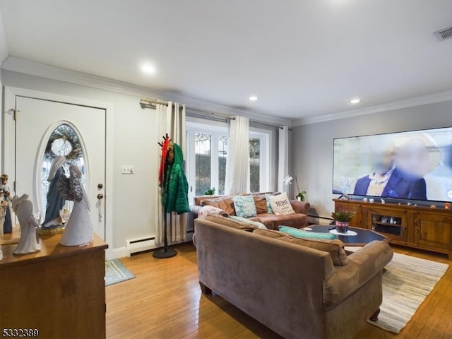 living room featuring light wood-type flooring, baseboard heating, and ornamental molding