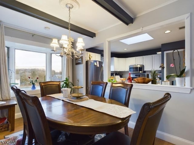 dining room featuring hardwood / wood-style floors, a skylight, ornamental molding, beam ceiling, and a chandelier