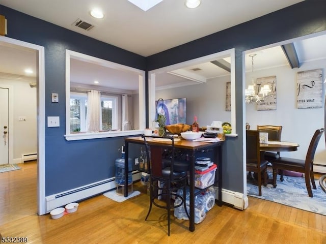 dining room with hardwood / wood-style flooring, an inviting chandelier, and a baseboard heating unit