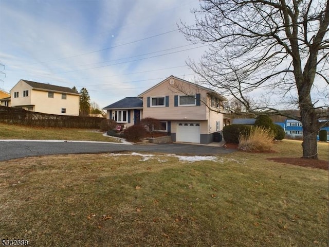 tri-level home featuring a garage and a front lawn