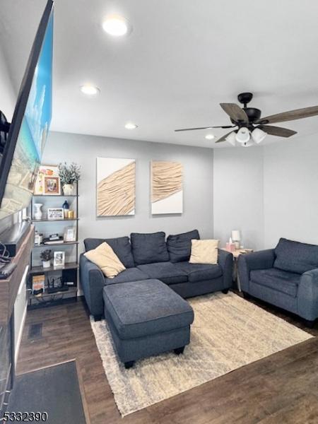 living room with ceiling fan and dark hardwood / wood-style flooring