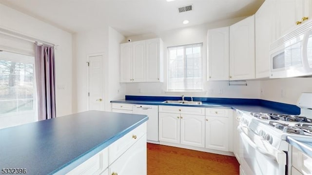 kitchen featuring white appliances, white cabinets, dark wood-type flooring, and sink