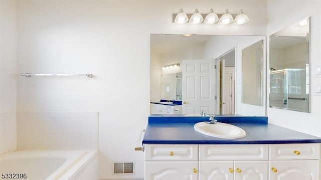 bathroom with vanity and separate shower and tub