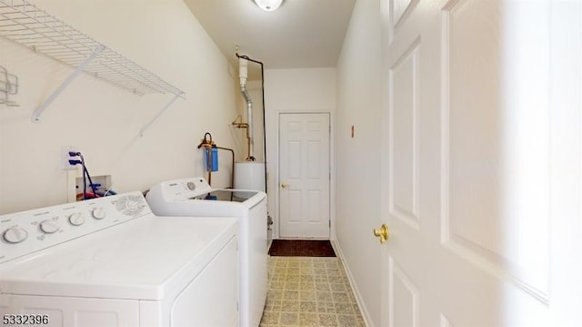 clothes washing area with washer and clothes dryer and gas water heater