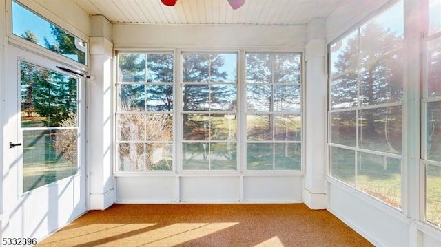 unfurnished sunroom with ceiling fan