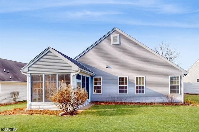 back of property featuring a lawn and a sunroom