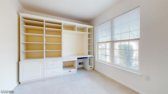 unfurnished office with built in desk and light colored carpet