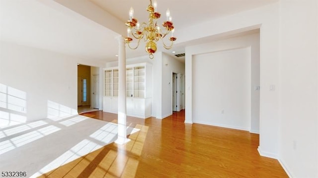 unfurnished room with hardwood / wood-style floors and a chandelier