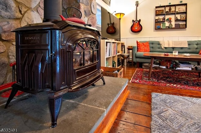 living area featuring a wood stove and hardwood / wood-style floors