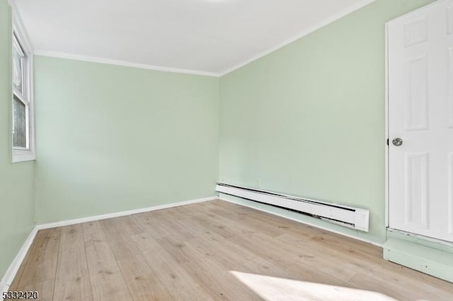 empty room with baseboard heating, light hardwood / wood-style floors, and ornamental molding