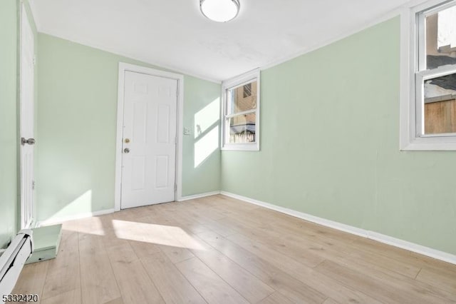 entrance foyer featuring a baseboard heating unit and light wood-type flooring