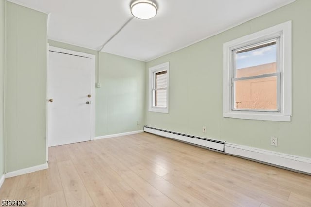 unfurnished room featuring light hardwood / wood-style floors and a baseboard radiator