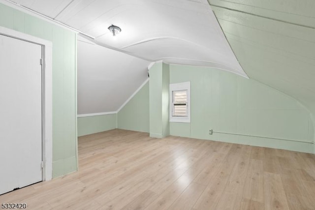 bonus room with lofted ceiling and light hardwood / wood-style floors