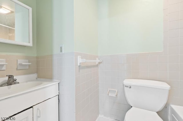 bathroom featuring tile walls, toilet, a shower, and vanity